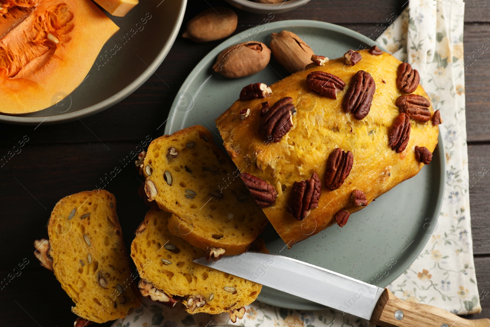 Photo of Delicious pumpkin bread with pecan nuts on wooden table, flat lay