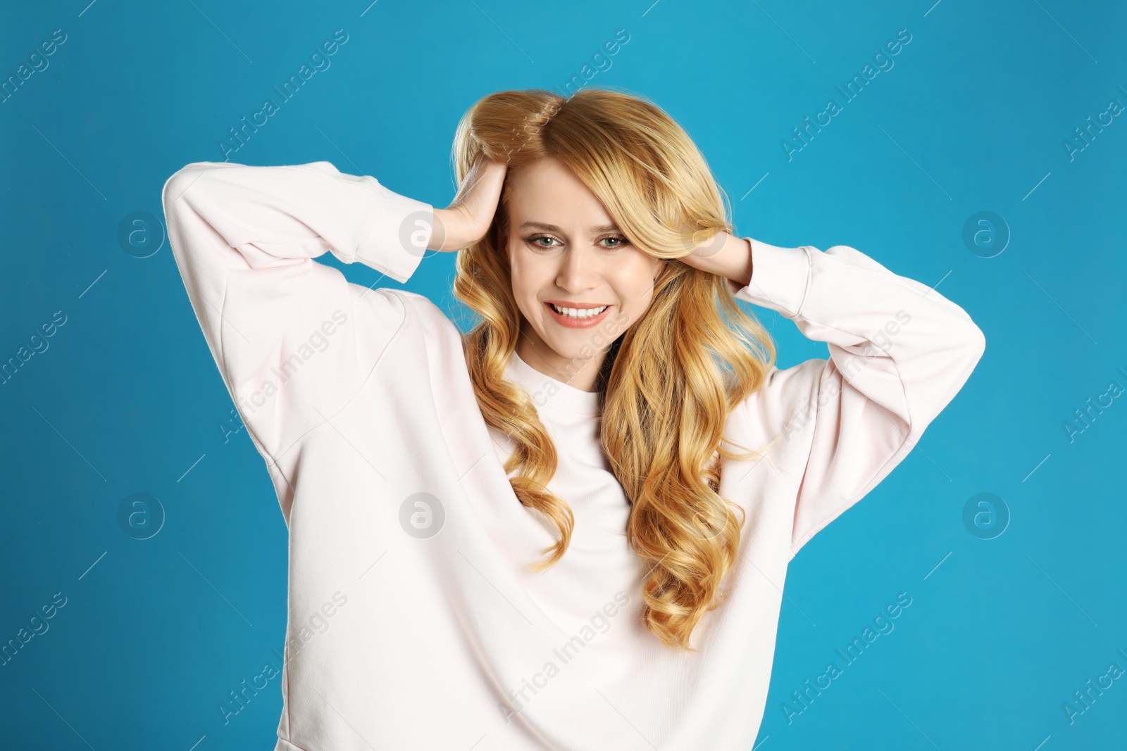 Photo of Portrait of beautiful young woman with dyed long hair on blue background