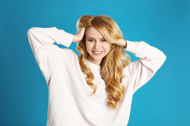 Portrait of beautiful young woman with dyed long hair on blue background