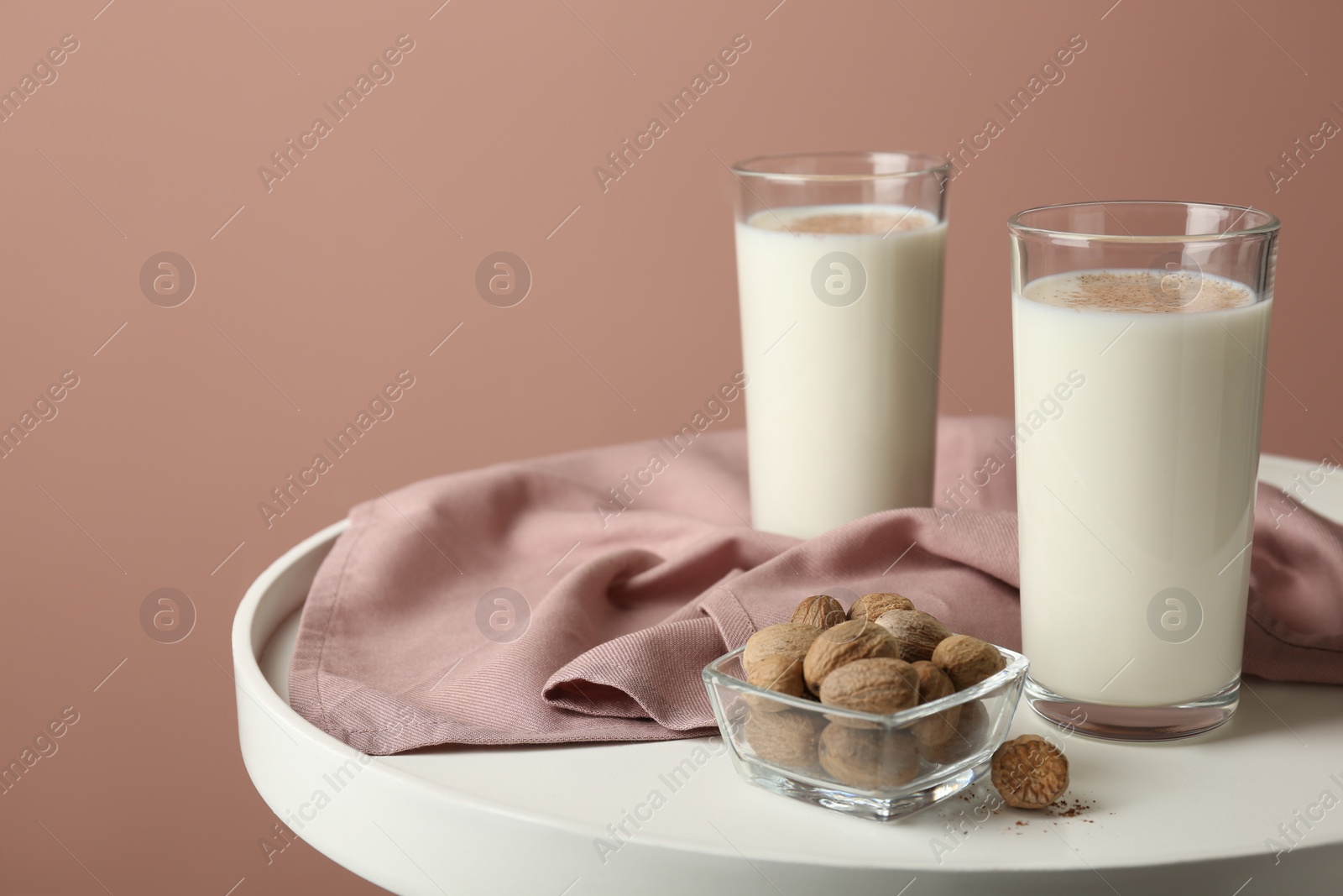 Photo of Milk and nutmeg seeds on white table