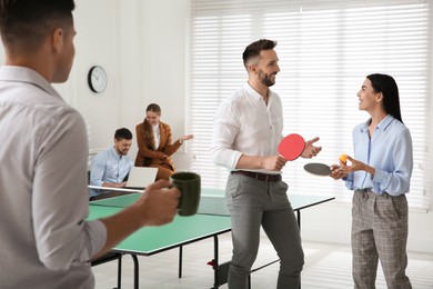 Photo of Business people talking near ping pong table in office