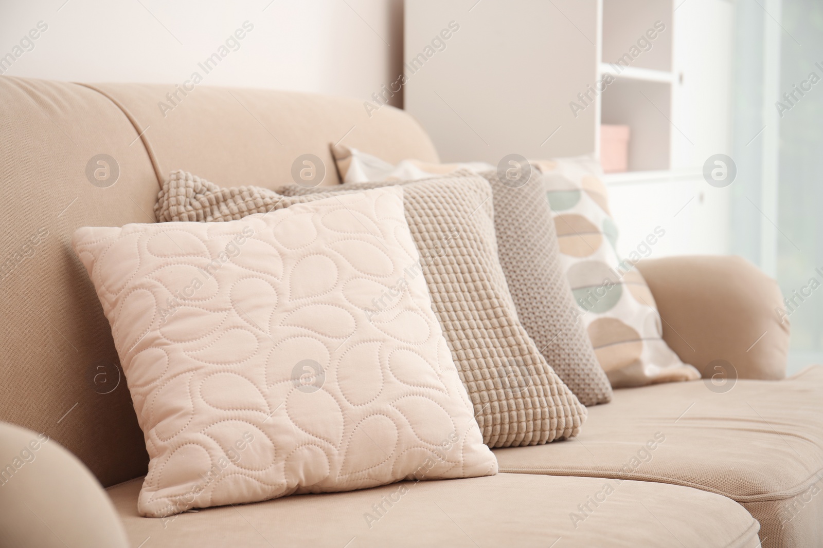 Photo of Different soft pillows on sofa in room
