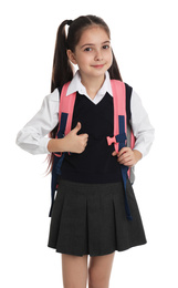 Little girl in school uniform with backpack on white background