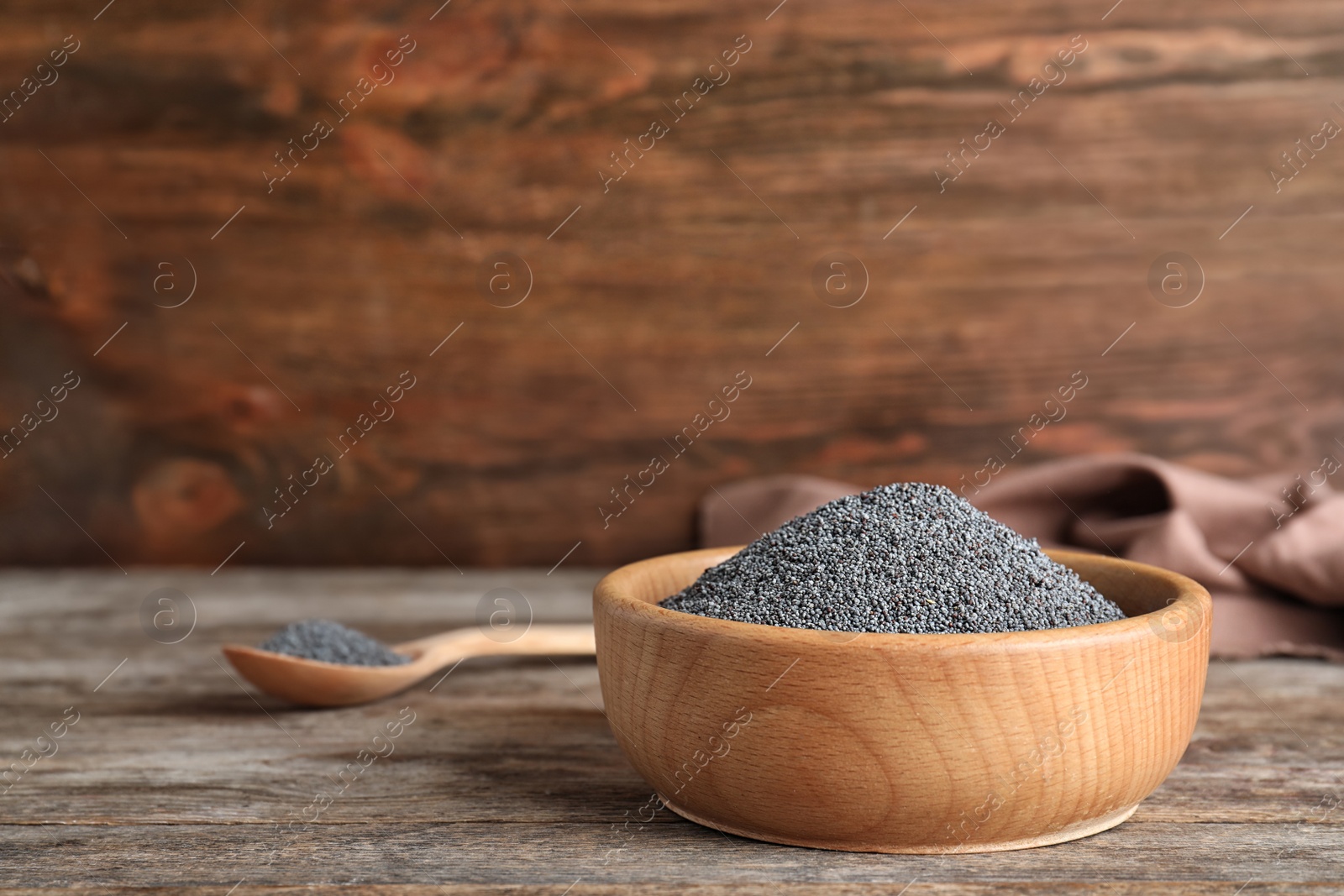 Photo of Poppy seeds in bowl on table. Space for text