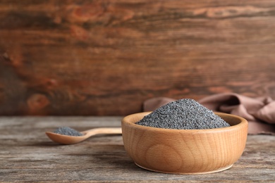 Photo of Poppy seeds in bowl on table. Space for text