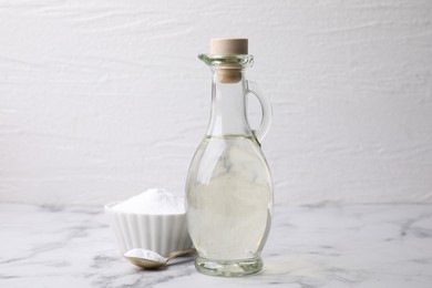 Photo of Vinegar and baking soda on white marble table