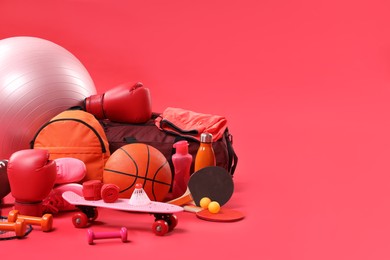 Many different sports equipment on red background, space for text