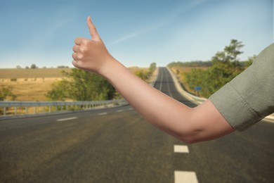 Image of Woman catching car on road, closeup. Hitchhiking trip