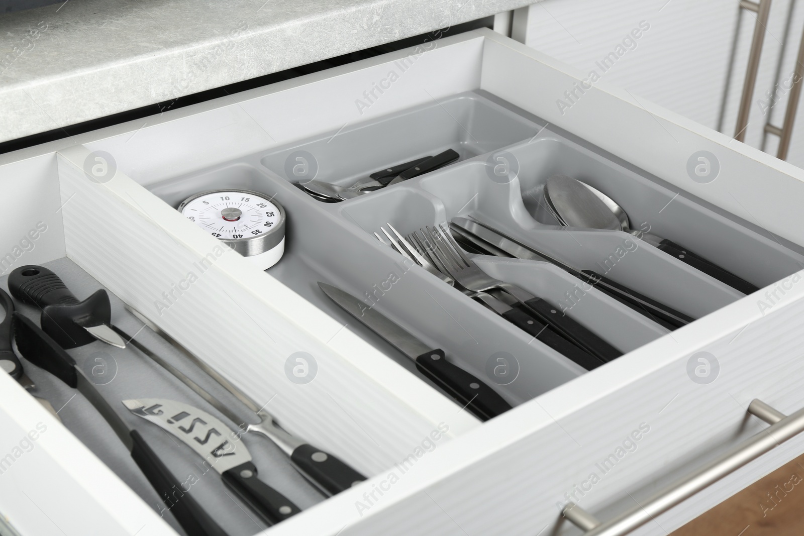 Photo of Open drawer with different utensils. Order in kitchen