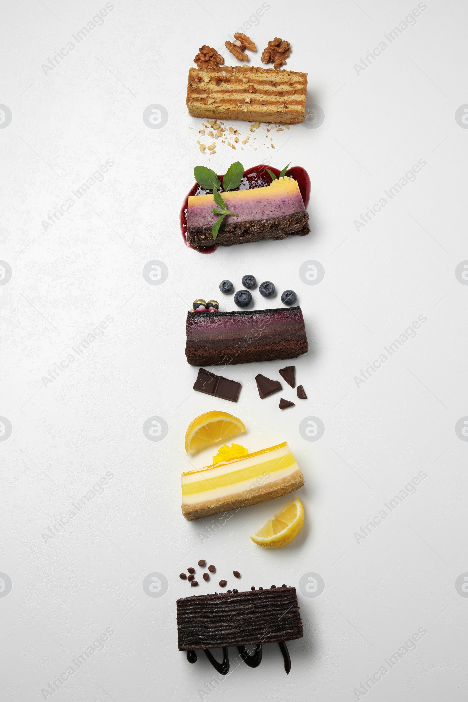 Photo of Flat lay composition with different tasty cakes on light table