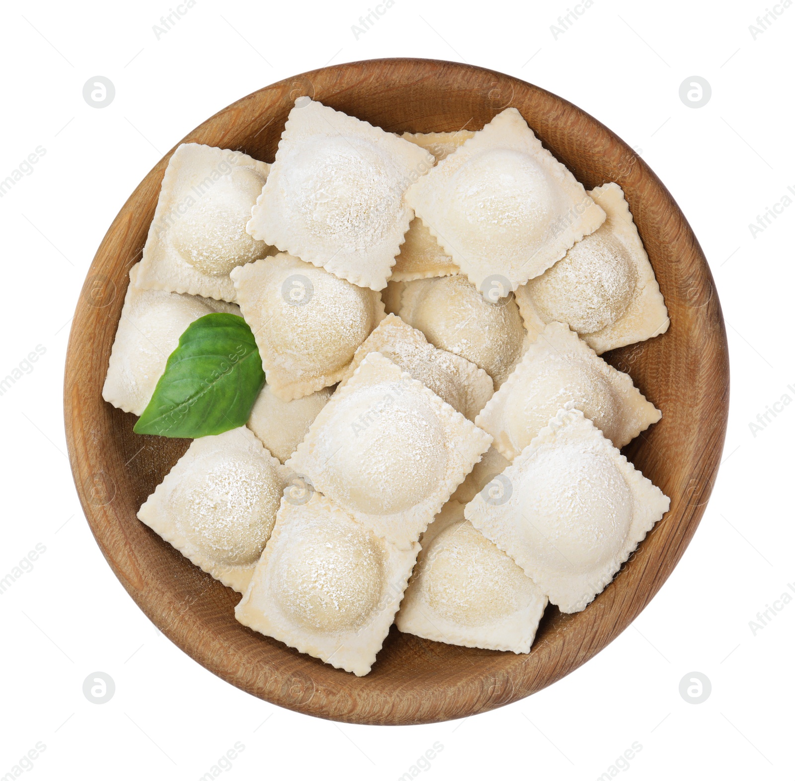 Photo of Uncooked ravioli and basil in wooden bowl on white background, top view