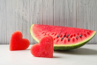 Photo of Juicy watermelon slices on table against light background