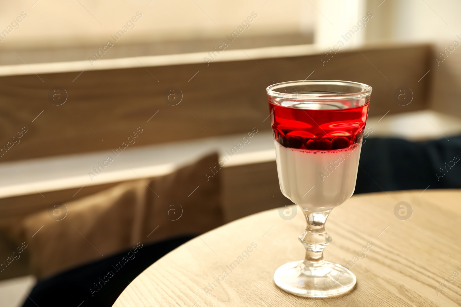 Photo of Delicious panna cotta dessert with berries on wooden table. Space for text