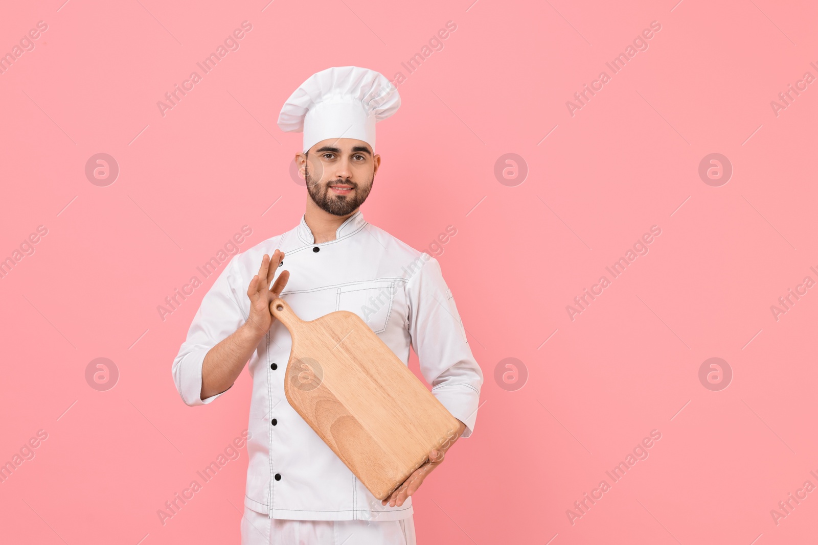 Photo of Professional chef with serving board on pink background. Space for text