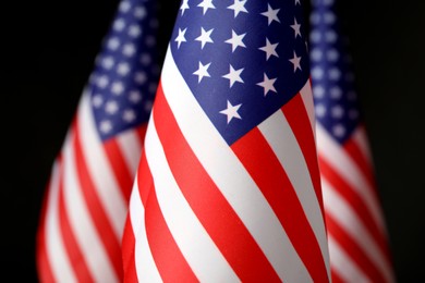 Photo of National flags of America on black background, closeup. Memorial day celebration