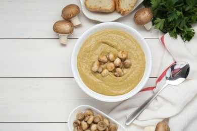 Delicious mushroom cream soup served on white wooden table, flat lay. Space for text