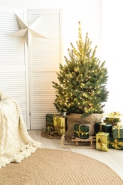 Photo of Many different gifts under Christmas tree indoors