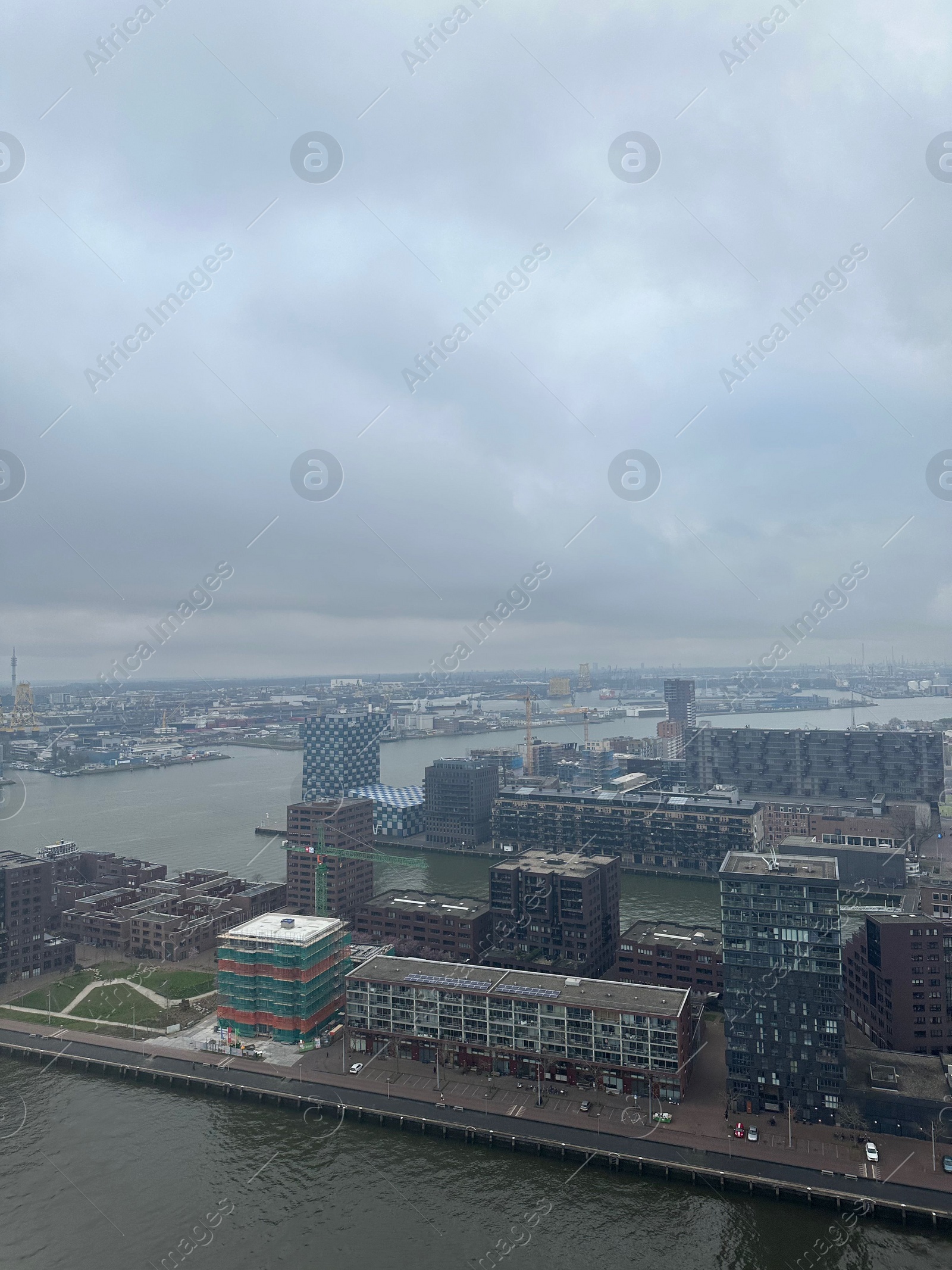 Photo of Picturesque view of city with modern buildings and harbor on cloudy day