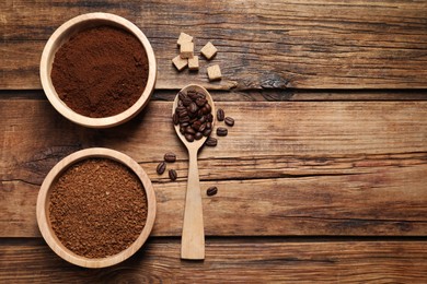 Instant and ground coffee, roasted beans and sugar on wooden table, flat lay. Space for text