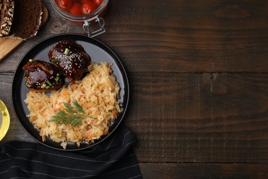 Photo of Plate with sauerkraut, chicken and products on wooden table, flat lay. Space for text