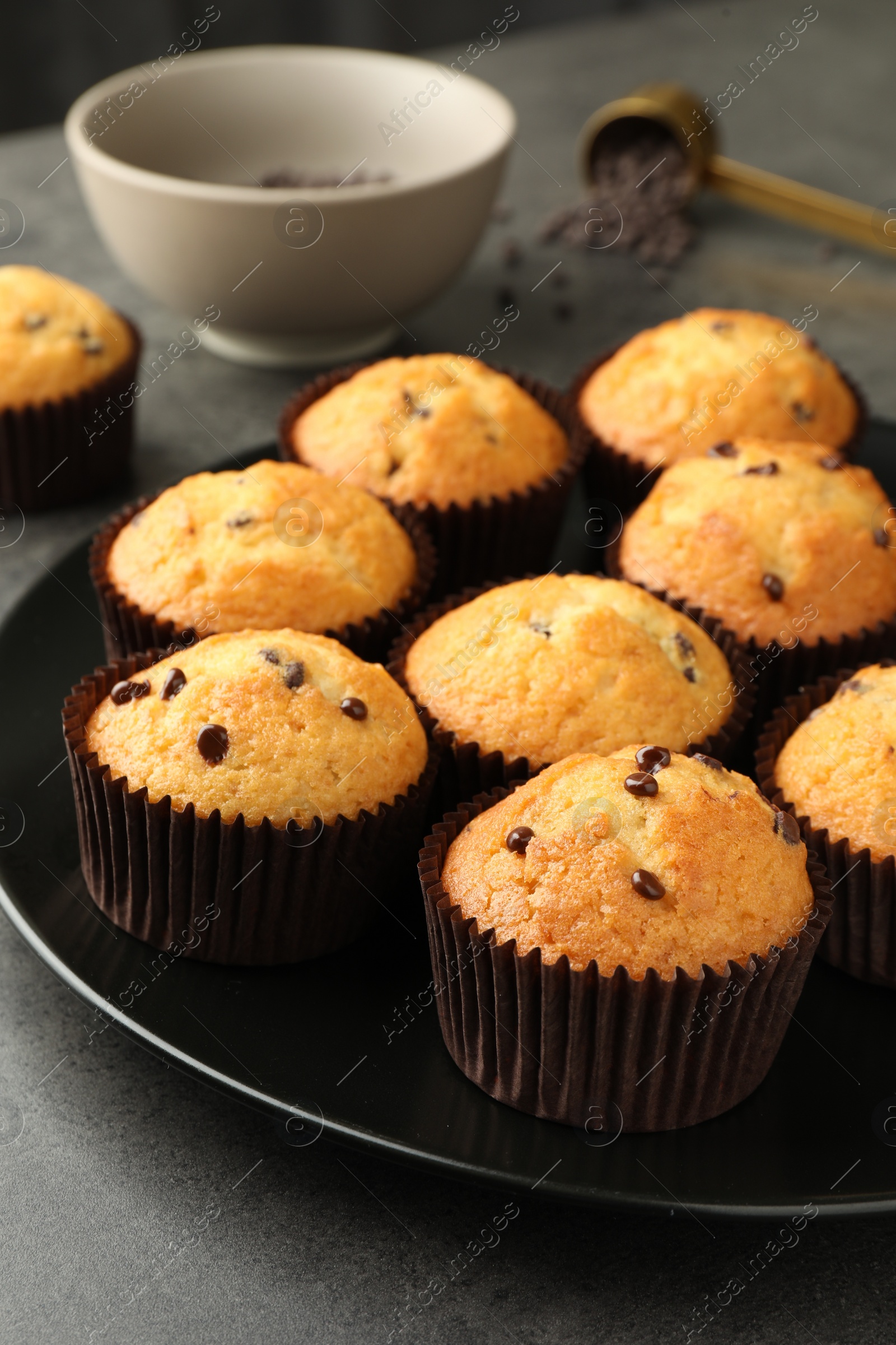 Photo of Delicious freshly baked muffins with chocolate chips on table, closeup