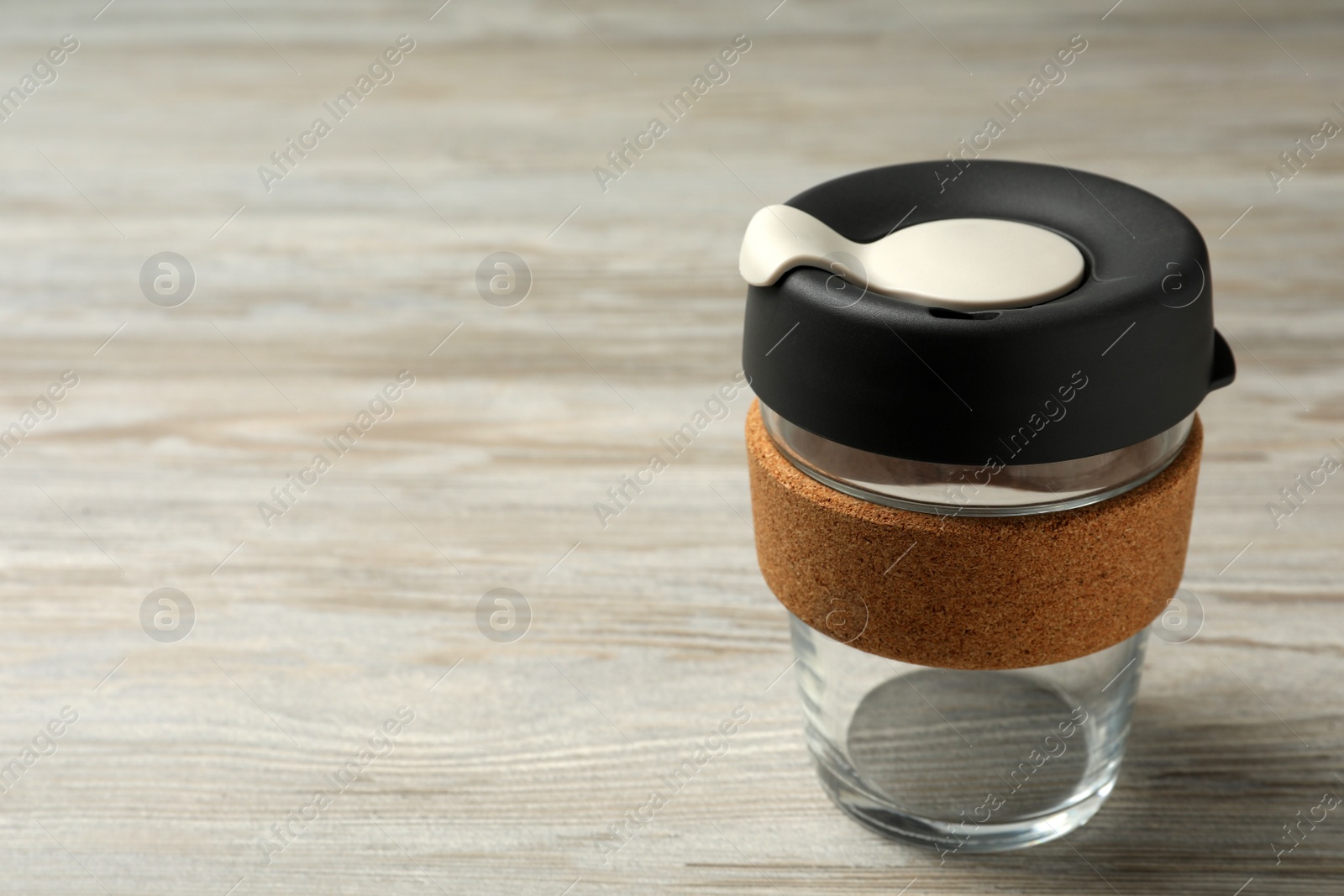 Photo of Glass cup with sleeve on wooden table, space for text. Conscious consumption