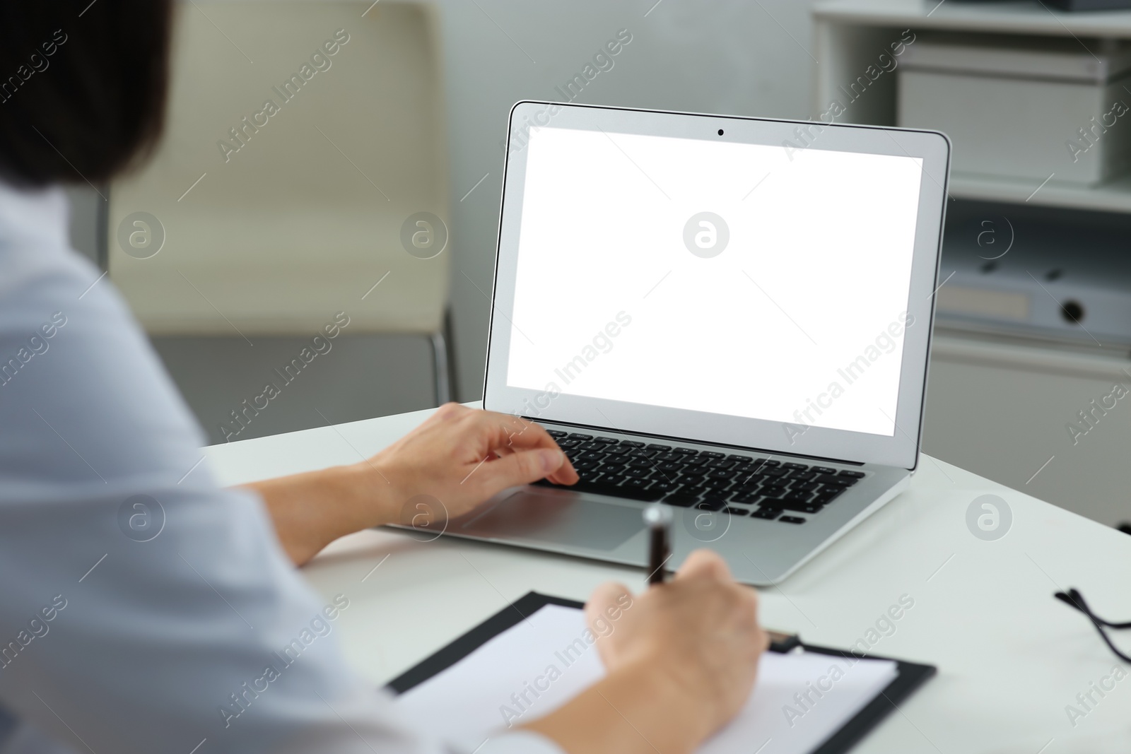 Photo of Doctor working with laptop at table in office. Hotline service
