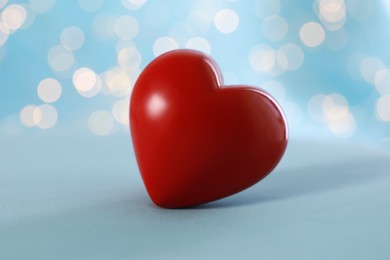Photo of Red decorative heart against blurred lights, closeup view