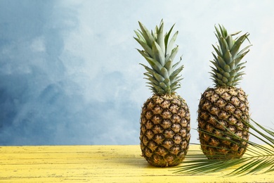 Photo of Fresh pineapples on wooden table