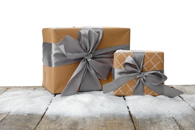 Photo of Christmas gift boxes and snow on table against white background