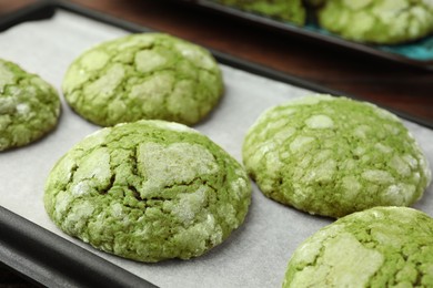 Baking tray with tasty matcha cookies on table, closeup