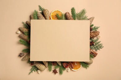 Flat lay composition with pinecones and blank card on beige background, space for text