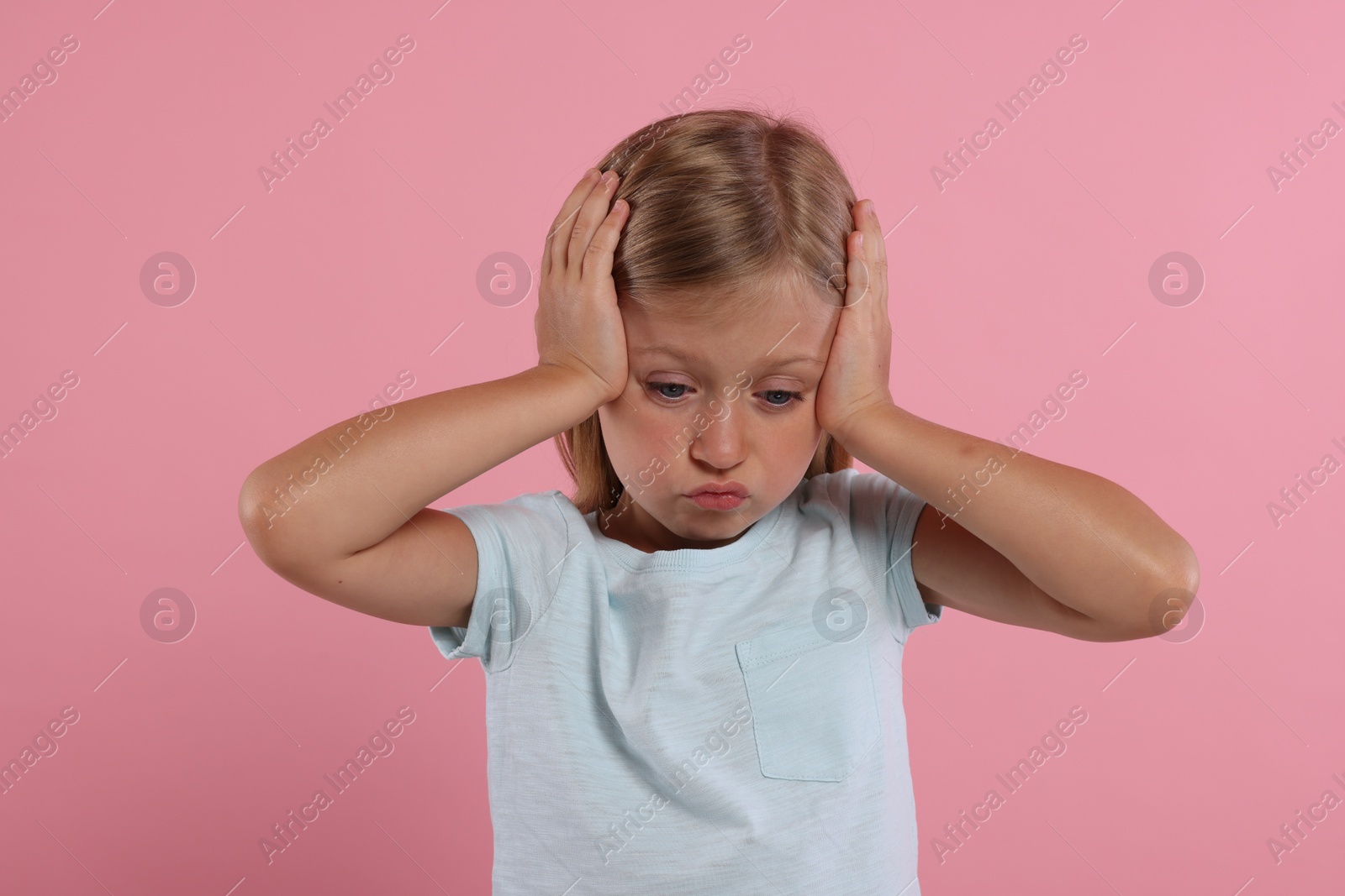 Photo of Resentment. Upset little girl on pink background