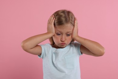 Photo of Resentment. Upset little girl on pink background