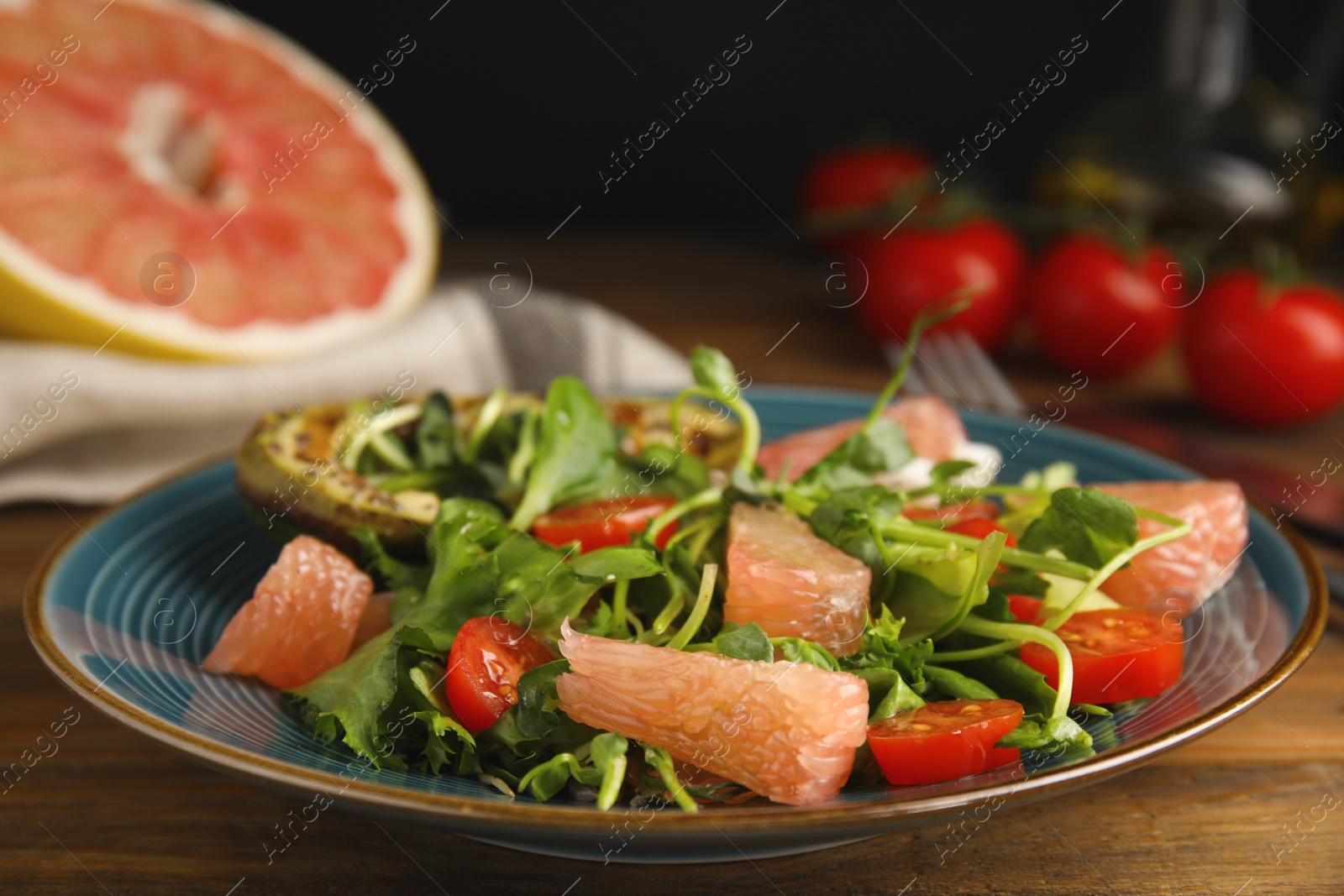 Photo of Delicious pomelo salad served on wooden table, closeup