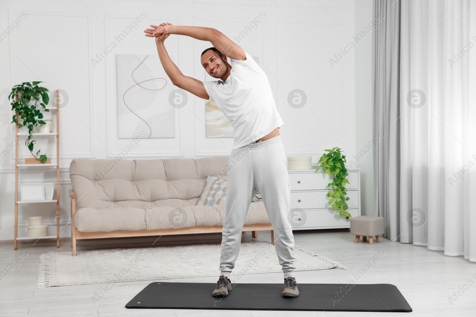 Photo of Man doing morning exercise on fitness mat at home