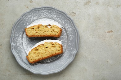 Pieces of delicious homemade yogurt cake with cream and powdered sugar on gray table, top view. Space for text