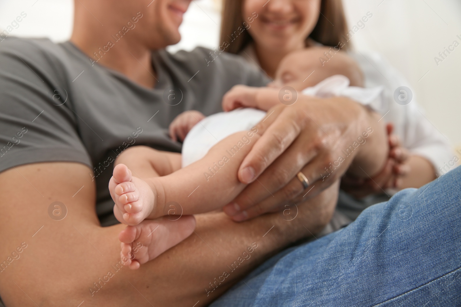 Photo of Happy couple holding their sleeping baby, closeup