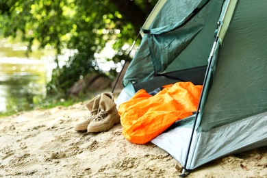 Photo of Camping tent with sleeping bag and boots on beach