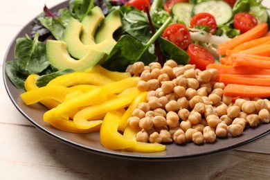 Photo of Balanced diet and vegetarian foods. Plate with different delicious products on wooden table, closeup