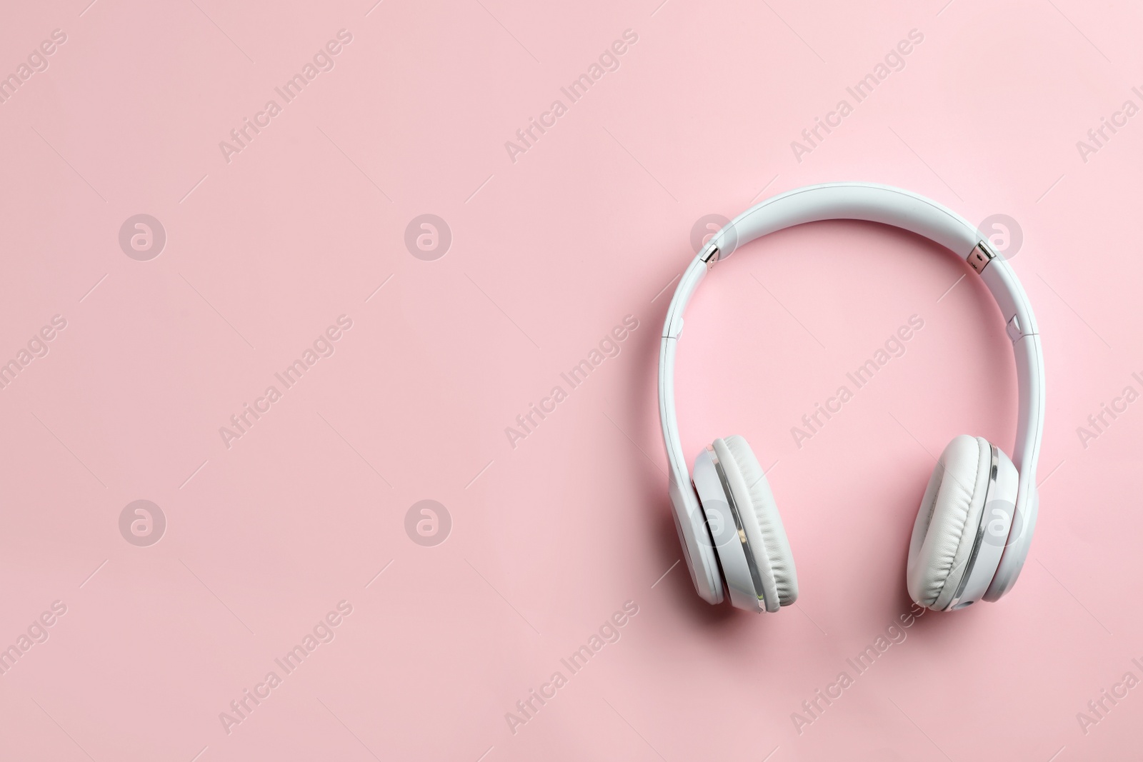 Photo of Wireless headphones on color background, top view. Space for text