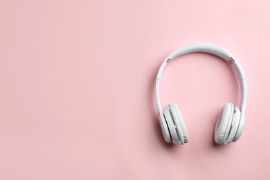 Photo of Wireless headphones on color background, top view. Space for text