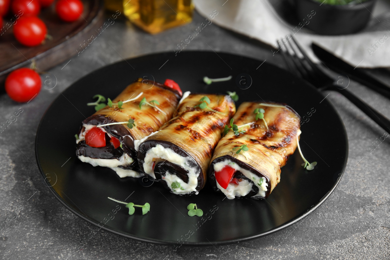 Photo of Delicious baked eggplant rolls served on grey table
