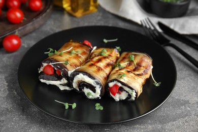 Delicious baked eggplant rolls served on grey table