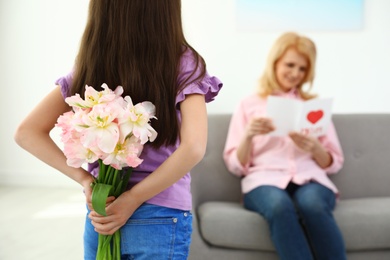 Little daughter congratulating her mature mom at home, closeup with space for text. Happy Mother's Day