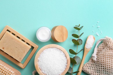 Photo of Jar of cream, body care products and eucalyptus branch on turquoise background, flat lay. Space for text