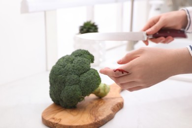 Photo of Woman cut finger while cooking in kitchen, closeup