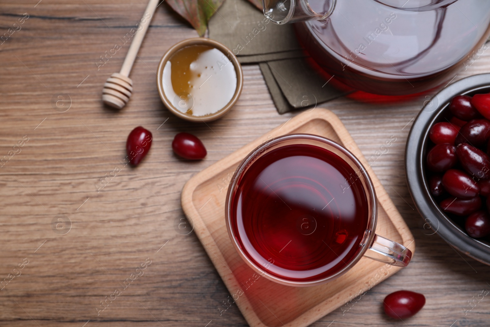 Photo of Flat lay composition with fresh dogwood tea and berries on wooden table. Space for text