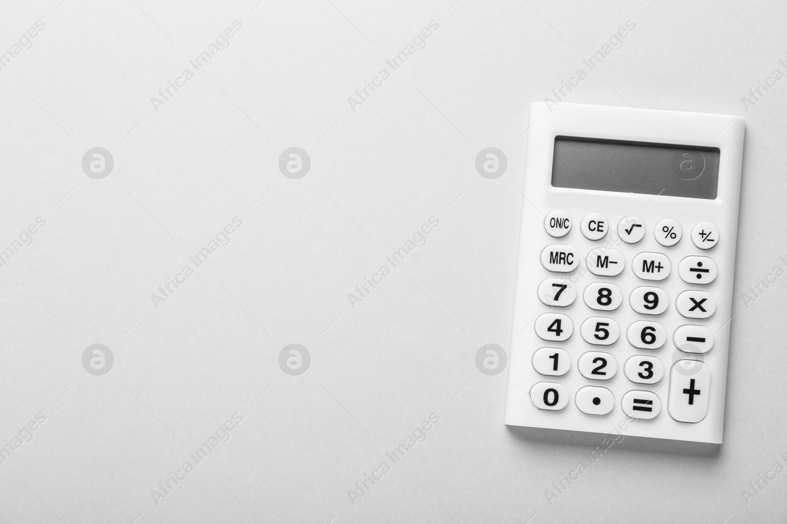 Photo of White calculator on light background, top view. Space for text