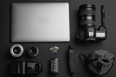 Flat lay composition with photographer's equipment and accessories on black background